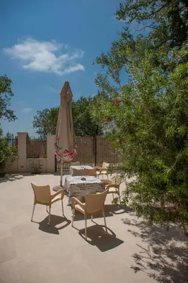 a patio with chairs and a table and an umbrella at Apartments Villa Simonovic in Petrovac na Moru