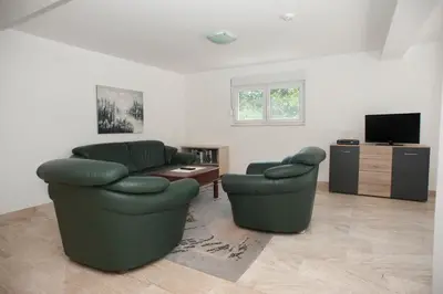 a living room with two chairs and a television at Apartments Villa Simonovic in Petrovac na Moru