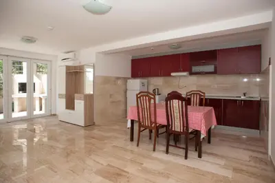 a kitchen with a table with chairs and a refrigerator at Apartments Villa Simonovic in Petrovac na Moru