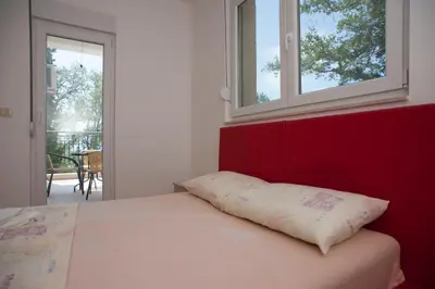 a bed with a pillow on it in a room at Apartments Villa Simonovic in Petrovac na Moru