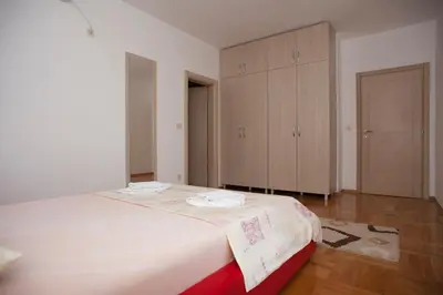 a bedroom with a large bed and a cabinet at Apartments Villa Simonovic in Petrovac na Moru