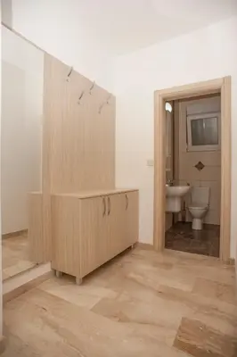 a bathroom with a wooden cabinet and a sink at Apartments Villa Simonovic in Petrovac na Moru