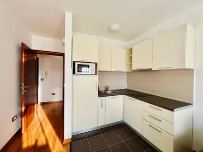 a kitchen with white cabinets and a black counter top at SeaScape in Bar