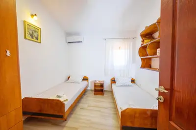a small room with two beds and a window at Apartmani Popović in Popovići
