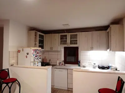 a kitchen with white cabinets and a white refrigerator at Apartmani Popović in Popovići