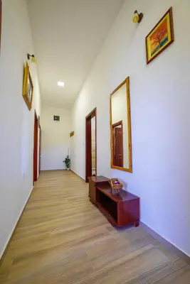 a hallway with a table and a mirror on a wall at Apartmani Popović in Popovići