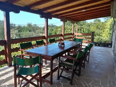 a wooden table and chairs on a patio at Apartmani Popović in Popovići
