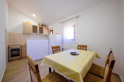 a kitchen with a table with a yellow table cloth on it at Apartmani Popović in Popovići