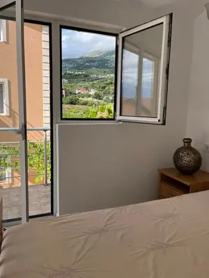 a bedroom with a bed and a large window at La Terrazza in Dobra Voda