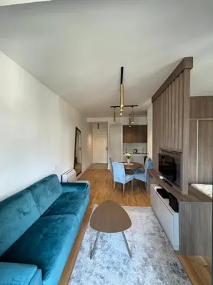 a living room with a blue couch and a table at Cozy sea view apt with garage in Budva