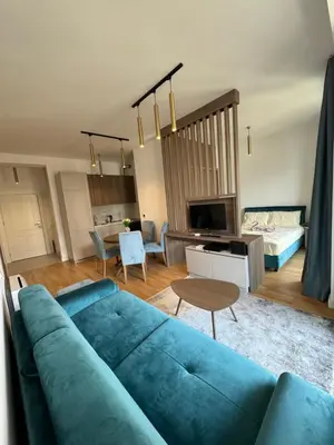 a living room with a blue couch and a table at Cozy sea view apt with garage in Budva