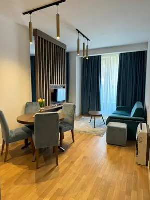 a living room with a table and chairs and a couch at Cozy sea view apt with garage in Budva