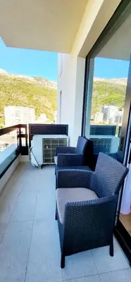 a balcony with two chairs and an air conditioner at MM Apartment in Budva