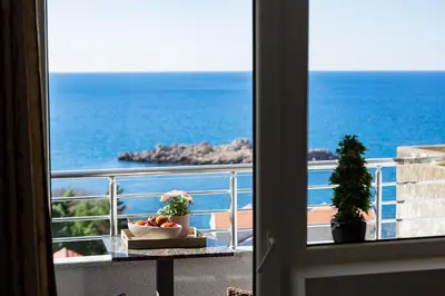 a room with a view of the ocean from a balcony at Villa Vanty in Sveti Stefan