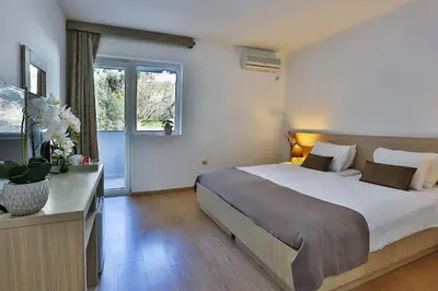 a bedroom with a large bed and a window at Villa Vanty in Sveti Stefan