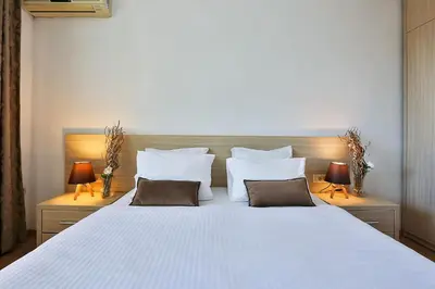 a bedroom with a large white bed with two lamps at Villa Vanty in Sveti Stefan