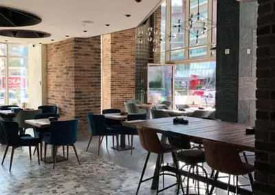 a restaurant with tables and chairs and a brick wall at Status-M Apartments WOW in Budva