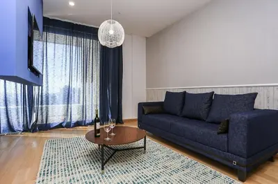a living room with a blue couch and a table at Status-M Apartments WOW in Budva
