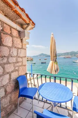 a patio with a table and chairs and an umbrella at Apartment More - Konoba More in Pržno