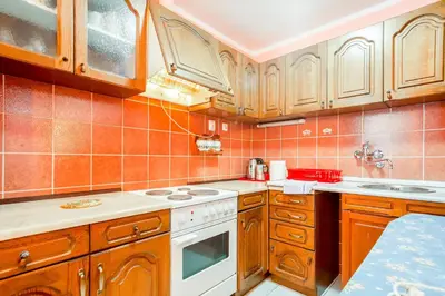 a kitchen with wooden cabinets and a white stove top oven at Apartment More - Konoba More in Pržno