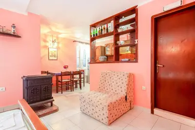 a living room with a chair and a stove at Apartment More - Konoba More in Pržno