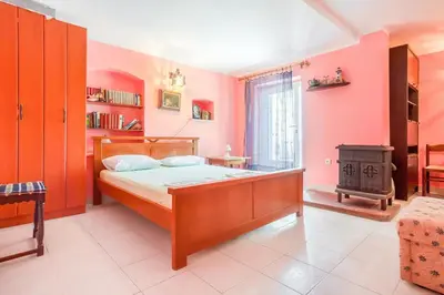 a bedroom with a bed and a wood stove at Apartment More - Konoba More in Pržno