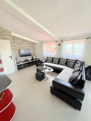 a living room with a black couch and a tv at Anchor 23 in Kotor
