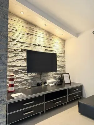 a living room with a television on a brick wall at Anchor 23 in Kotor