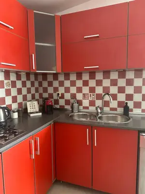 a kitchen with red cabinets and a sink at Anchor 23 in Kotor