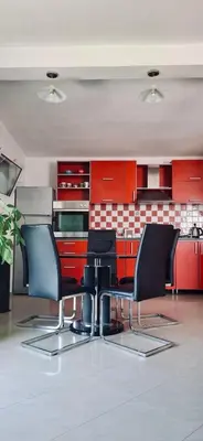 a kitchen with red cabinets and black chairs at Anchor 23 in Kotor