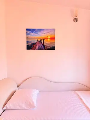 a bedroom with a bed with a picture on the wall at Anchor 23 in Kotor