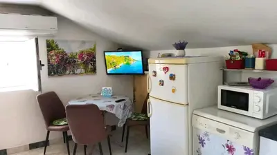 a small kitchen with a white refrigerator and a table at SunRoof Apartments in Budva