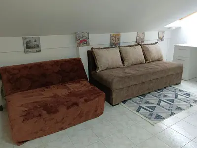 a living room with a couch and a ottoman at SunRoof Apartments in Budva