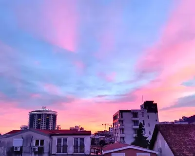a city skyline with a cloudy sky at sunset at SunRoof Apartments in Budva