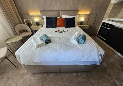a bedroom with a large bed with pillows on it at AGAPE Apartment in Podgorica