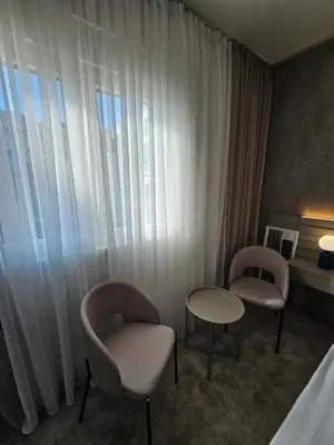 two chairs and a table in a hotel room at AGAPE Apartment in Podgorica