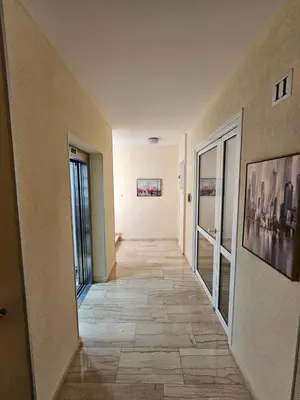 a hallway with a tile floor in a building at AGAPE Apartment in Podgorica