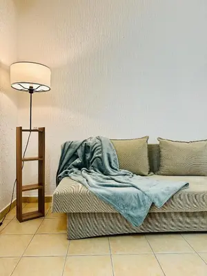a couch with a blanket on it next to a lamp at SweetHome in Sutomore