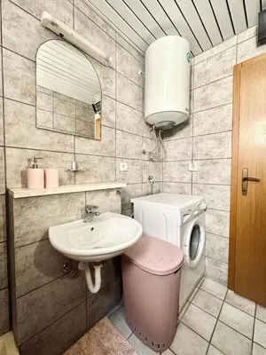 a bathroom with a sink and a washing machine at SweetHome in Sutomore
