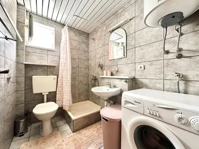 a bathroom with a toilet sink and a washing machine at SweetHome in Sutomore