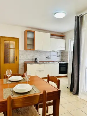 a kitchen with a wooden table with two plates on it at SweetHome in Sutomore