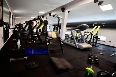a gym with several tread machines in a room at Andrej home in Golubovci