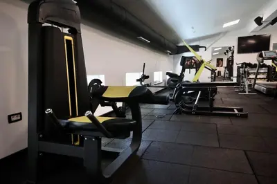 a gym with several tread machines in a room at Andrej home in Golubovci