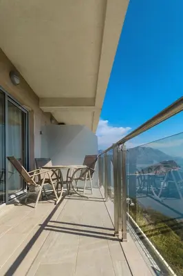 a balcony with a table and chairs on a balcony at Tophill Altezza 9 best view and pool in Budva