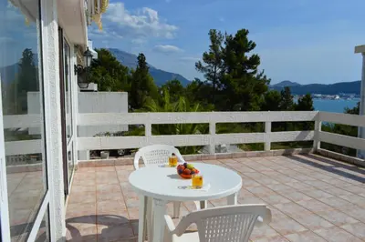 a white table and chairs on a patio with a view at Smokva in Bar