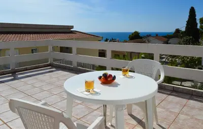 a white table and chairs with drinks on a balcony at Smokva in Bar