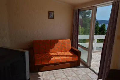 an orange chair sitting in front of a sliding glass door at Smokva in Bar