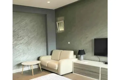 a living room with a white couch and a tv at Status-M Apartments Franca sea view in Budva
