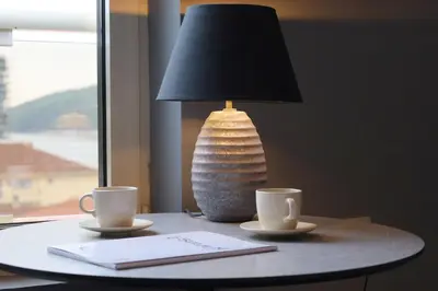 a table with two coffee cups and a lamp at Status-M Apartments Franca sea view in Budva