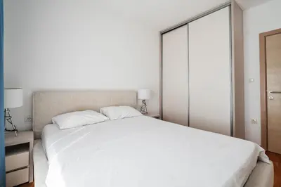 a bedroom with a large white bed and a closet at Status-M Apartments 153 in Becici